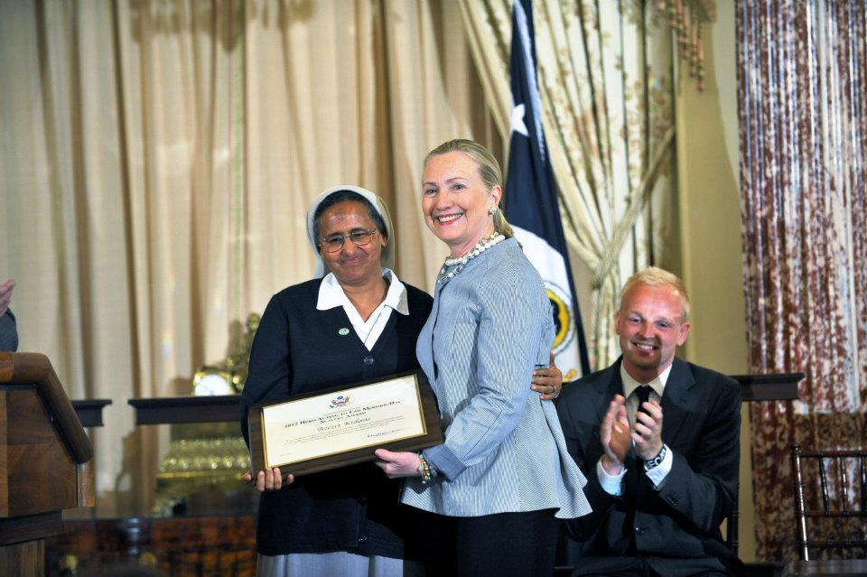 U.S. Secretary of State Hillary Rodham Clinton poses for a photo with the 2012 Trafficking in Persons (TIP) Report Heroes Sister Azezet Kidane, at the U.S. Department of State in Washington, D.C., on June 19, 2012. [State Department photo/ Public Domain].